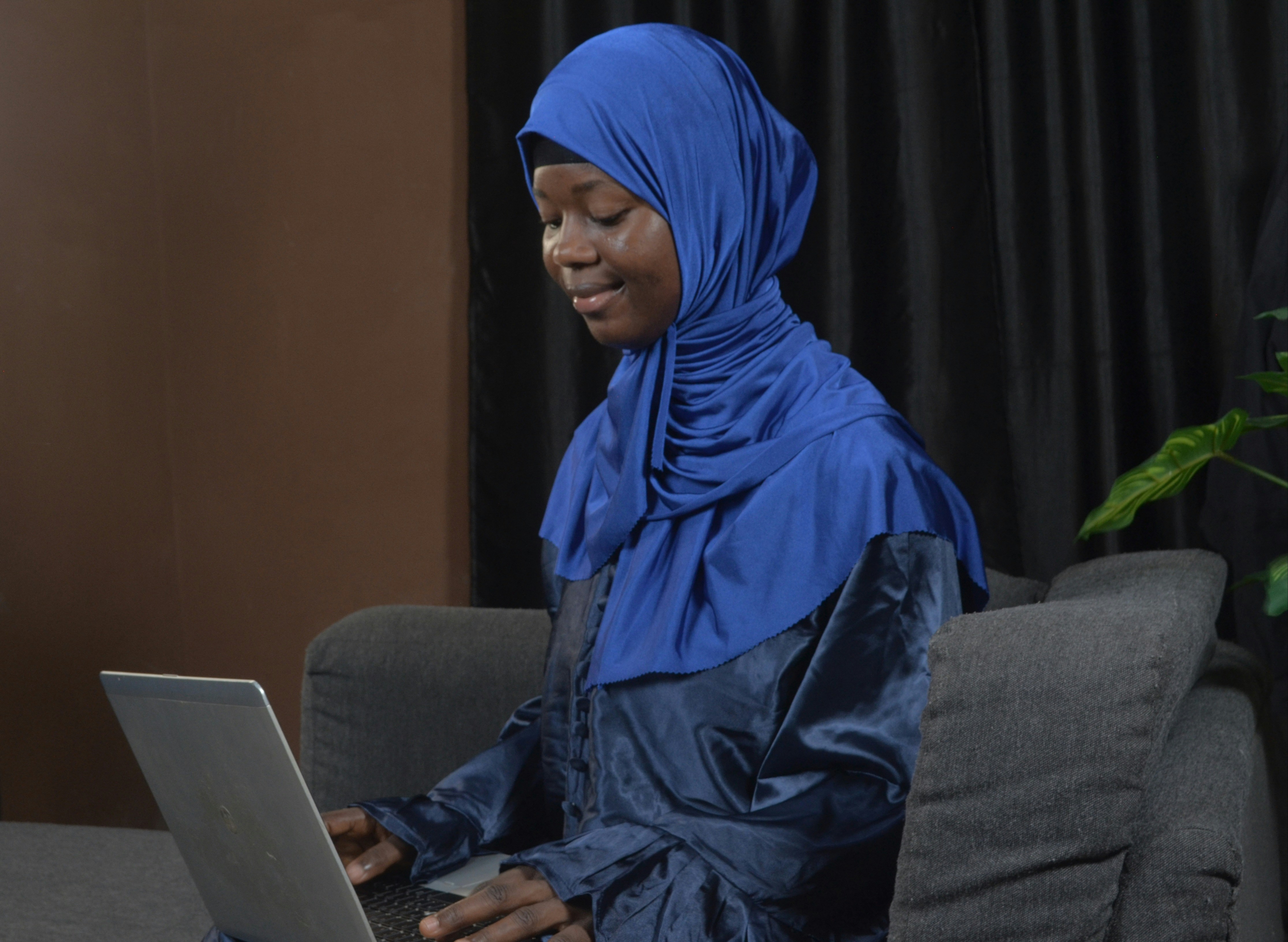 Woman with blue headscarf using laptop