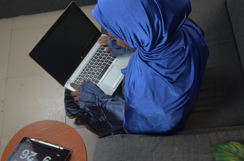 a person sitting on a couch with a laptop