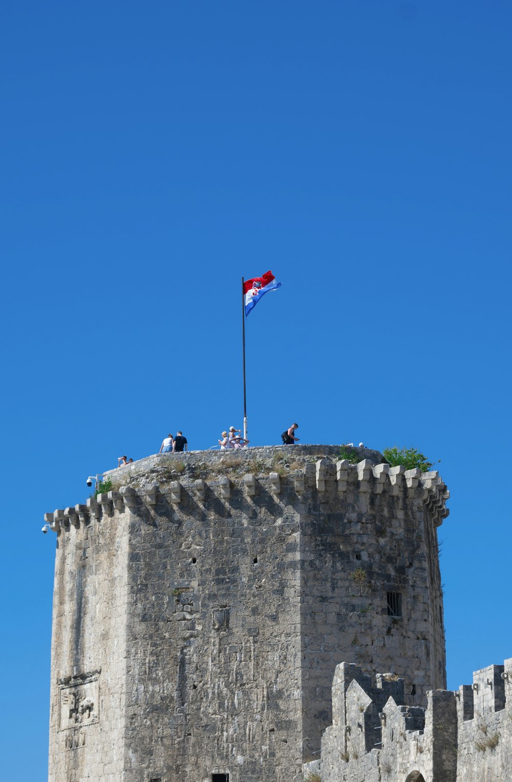 a flag flying on top of a stone building
