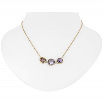 Elegant gemstone necklace displayed on a sleek black bust