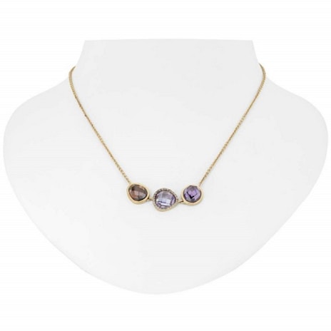 A gold necklace with three distinct gemstone pendants displayed on a white bust. The pendants include a brown, a clear, and a purple gemstone, each encased in a gold setting.
