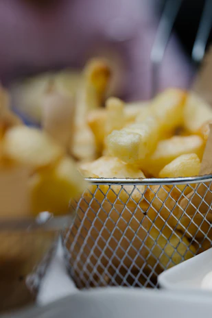 Happy customer enjoying a crispy golden fry basket with a warm smile in a cozy restaurant setting.