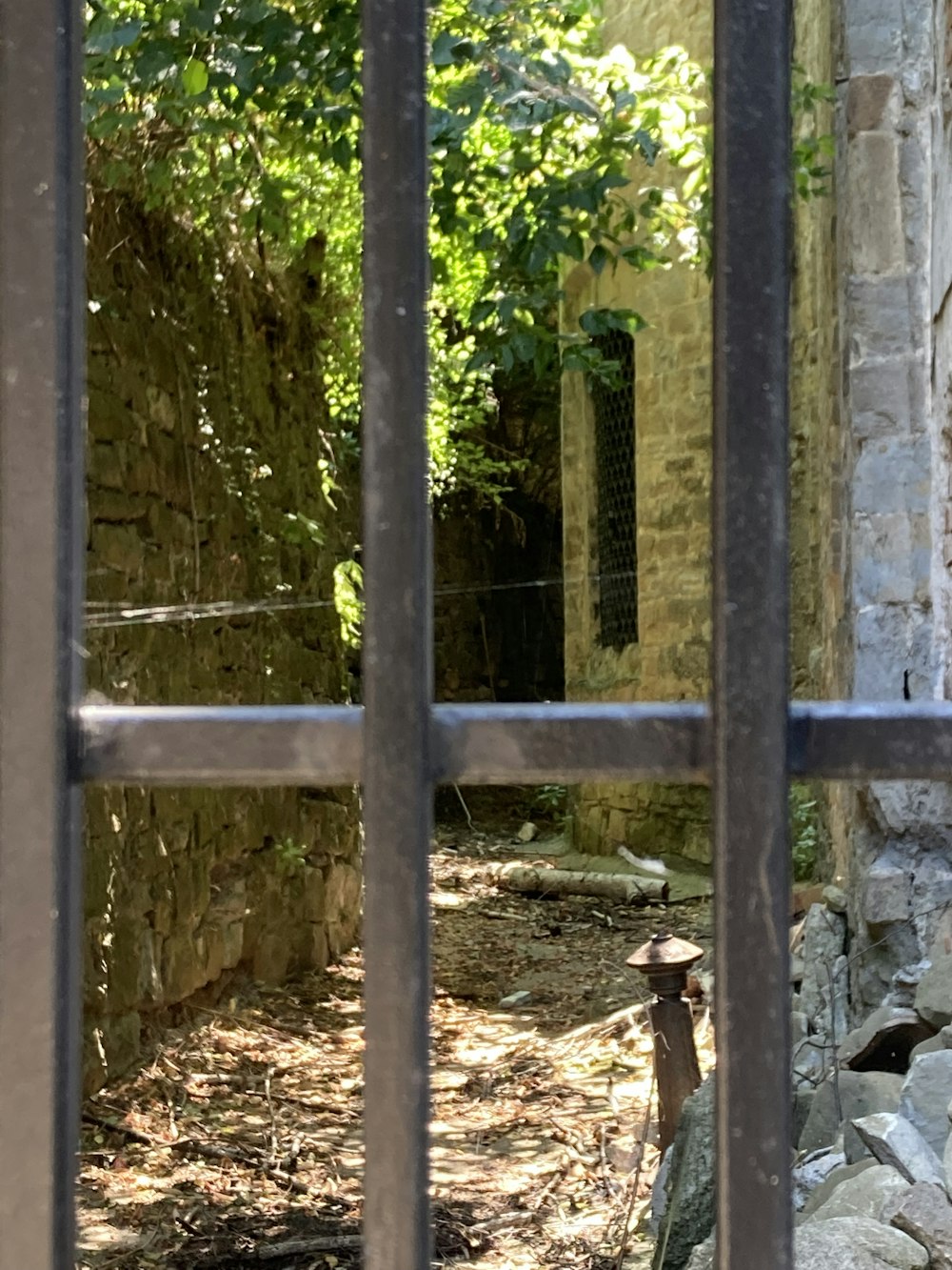 a wooden fence with a stone wall and trees in the background