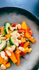 A colorful plate of fresh salad with tomatoes, cucumbers, and greens.