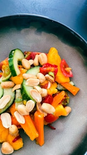 A colorful plate of fresh summer salad with tomatoes, cucumbers, and herbs.