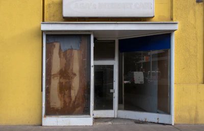 An empty storefront window with a notice of closure taped inside.