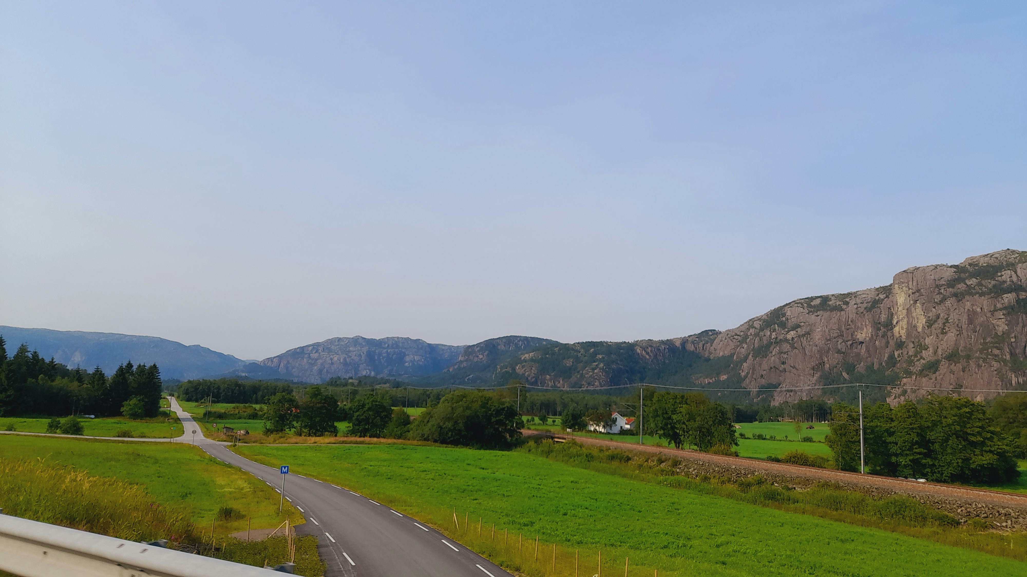 a road with grass and trees on the side
