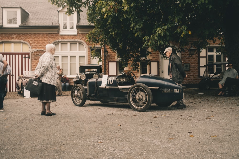 a group of people looking at a car