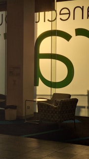 A warm, inviting office space with soft lighting and a welcoming chair by a window.