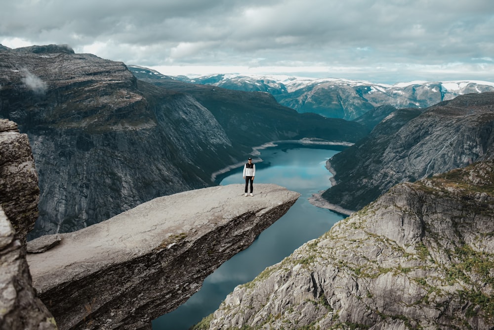 a person standing on a cliff above a body of water