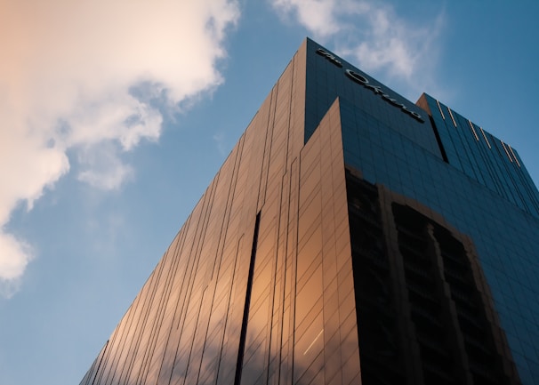 High-altitude shot of a modern commercial building with reflective glass, framed by clear blue skies.
