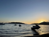 Sunset casting golden light over a jetski tour cruising along the coastline.
