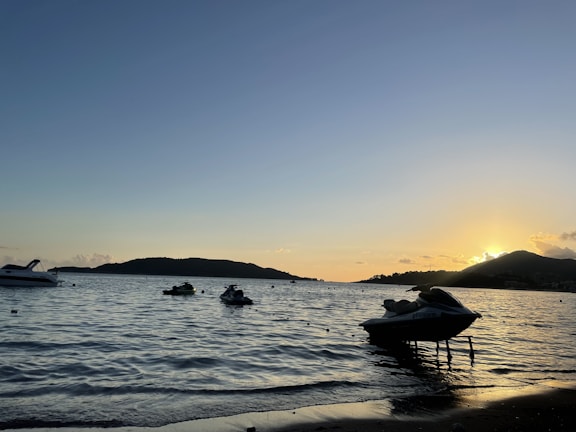 Sunset casting golden light over a jetski tour cruising along the coastline.