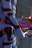 A futuristic scene featuring a humanoid figure with metallic armor-like pieces interspersed on a blue body. The setting includes abstract, twisting shapes and a glossy surface, with a mix of dark and vibrant colors creating an otherworldly appearance.