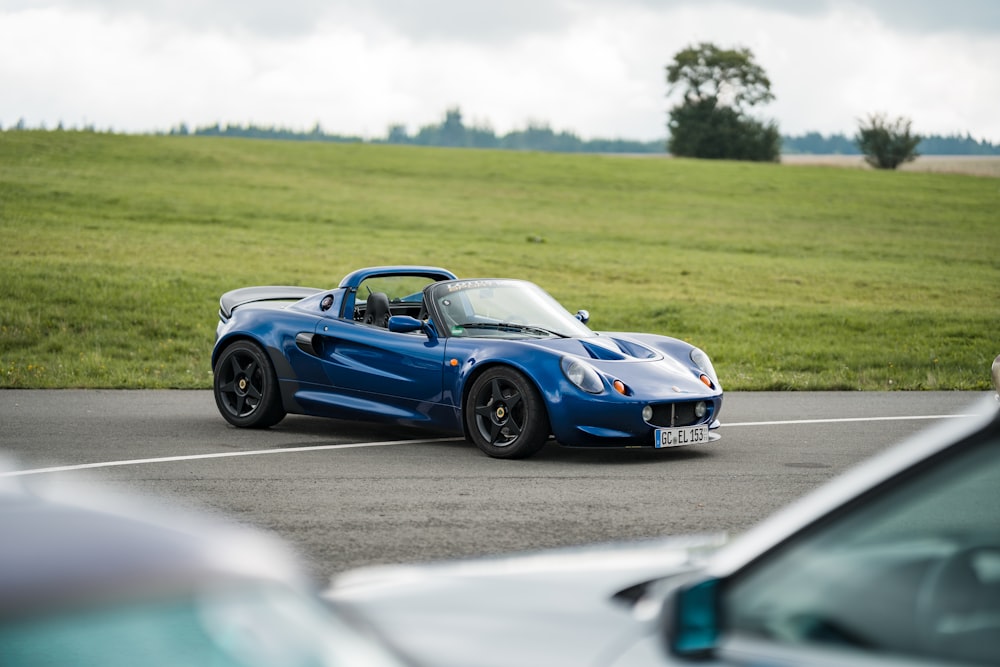 a blue sports car on a road