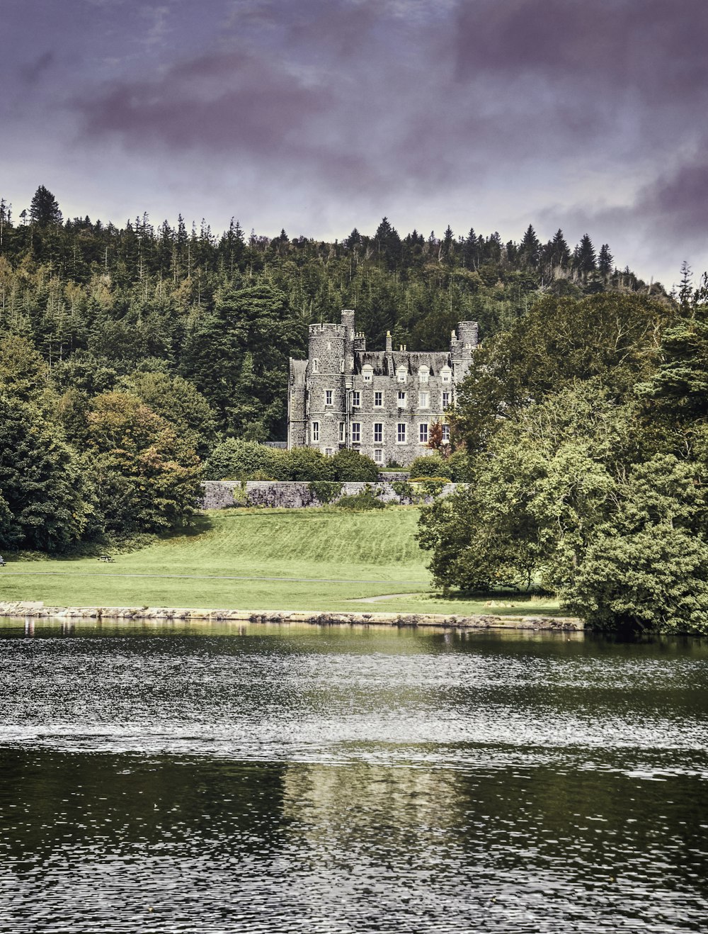 a castle on a hill by a river