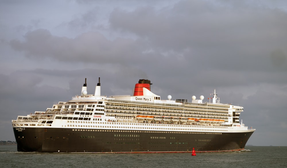 a large cruise ship with RMS Queen Mary in the background