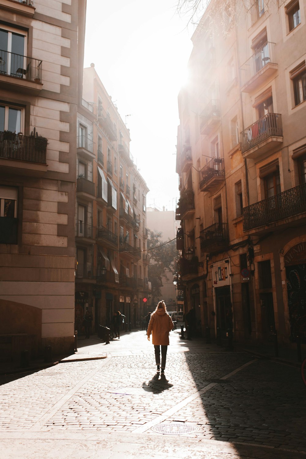 a person walking down a street between buildings