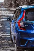 a blue car parked on a gravel road