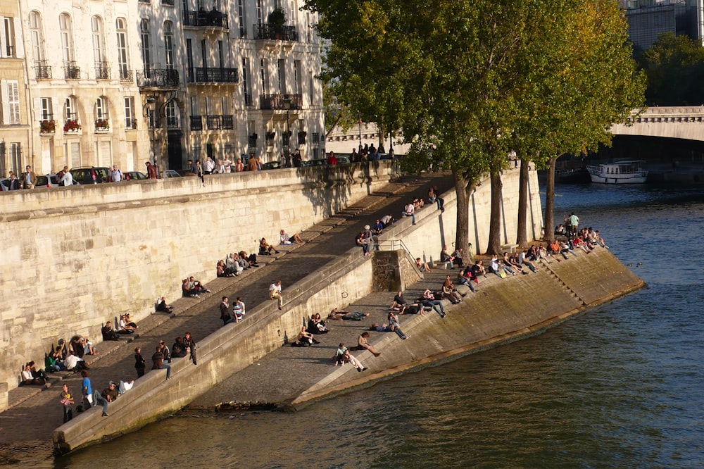 a river with people sitting on the side of it