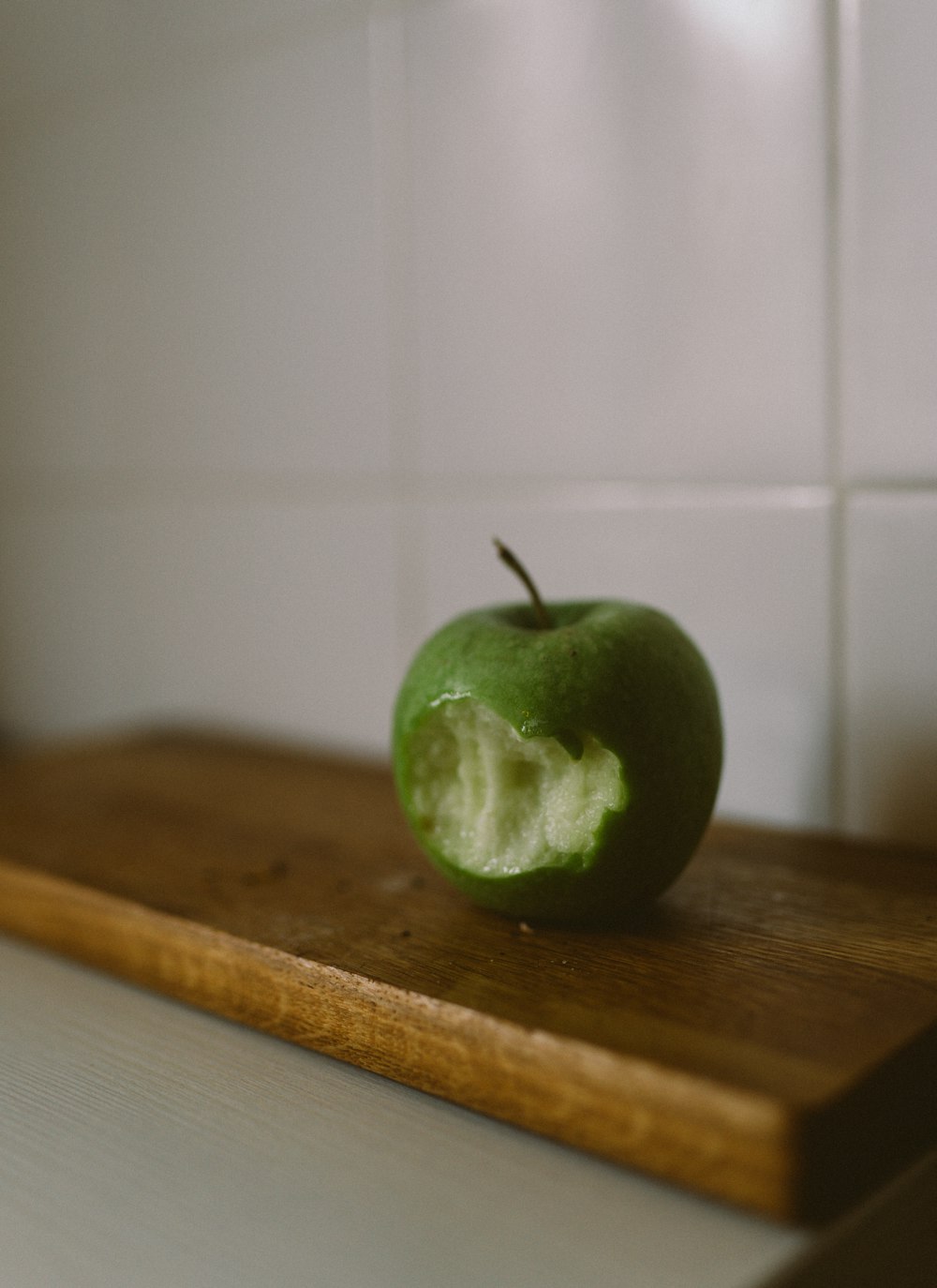 a green apple on a wooden surface