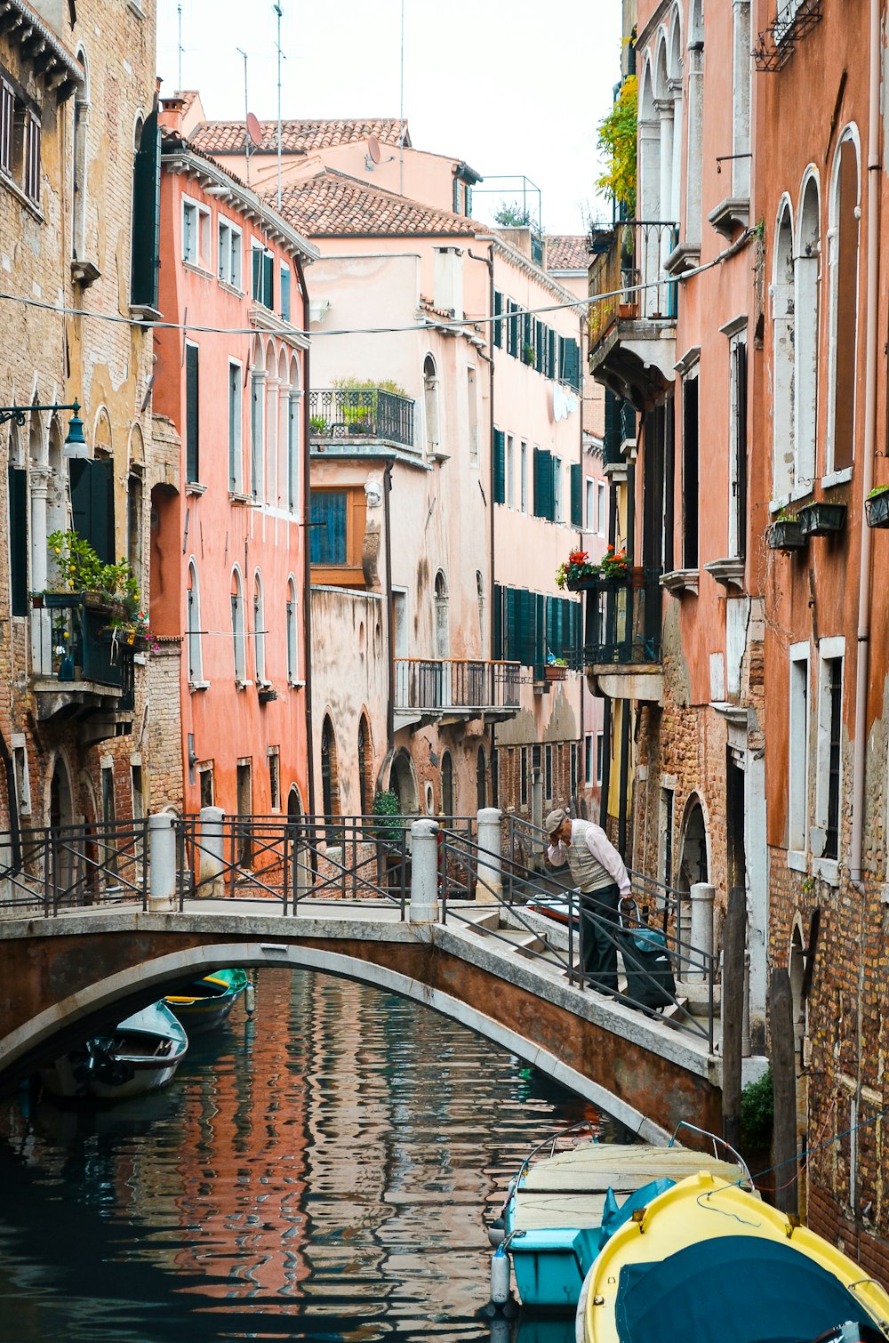 a person riding a bicycle on a bridge over a canal