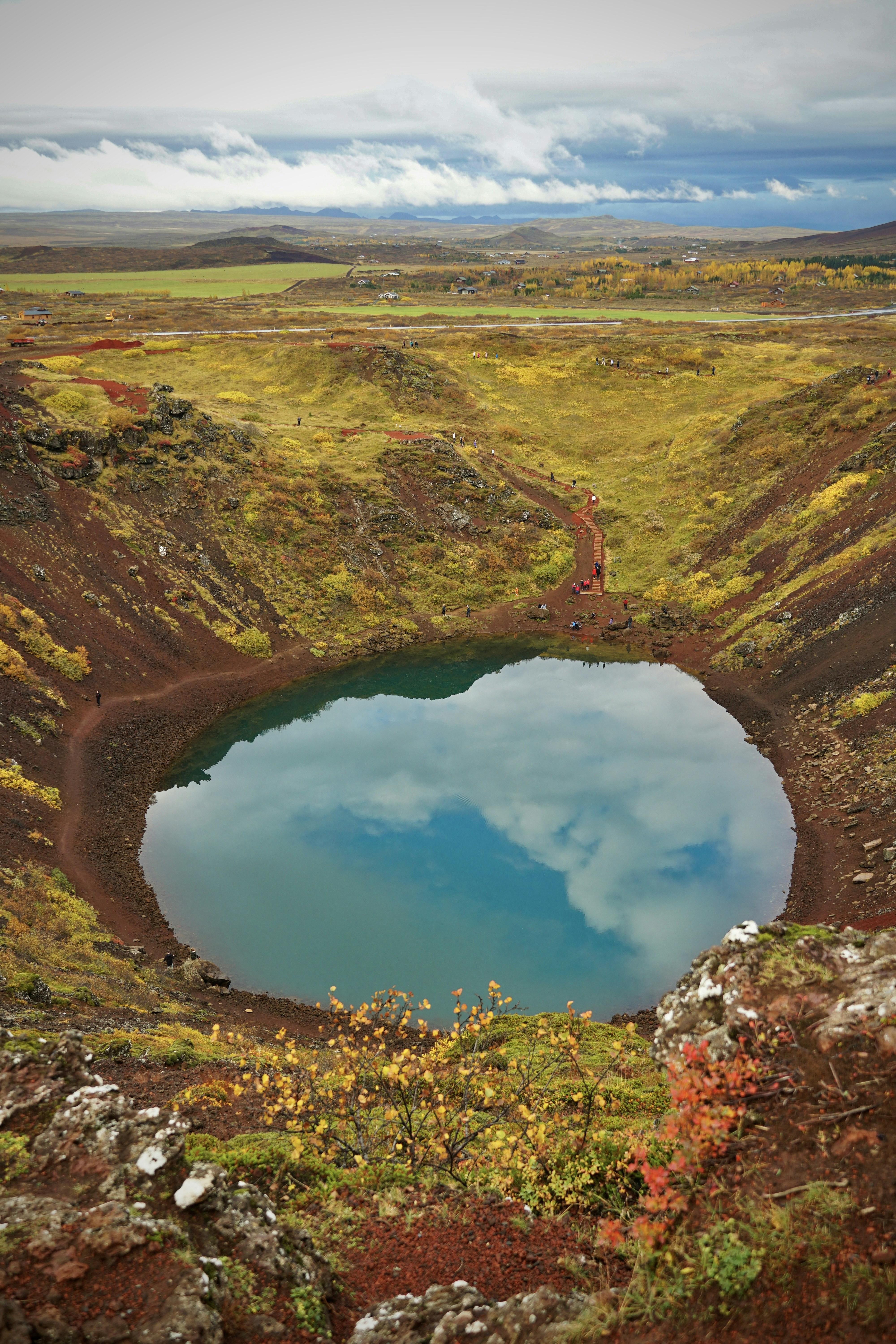 a large body of water surrounded by grass and trees