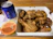 A happy customer enjoying a box of crispy salt and pepper chicken at home.