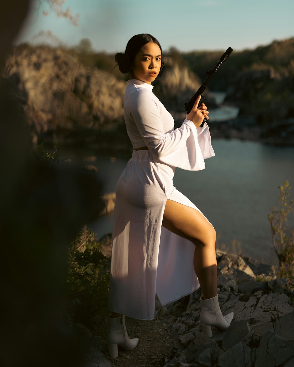 a woman in a white dress holding a gun