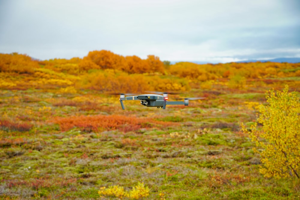 a helicopter flying over a field