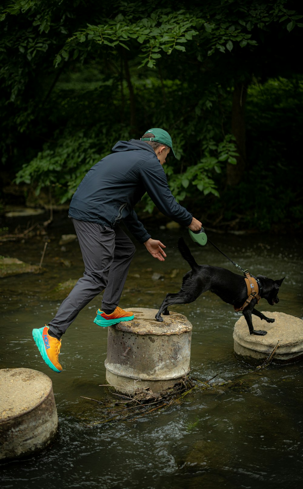 a man with a dog on a rock in a river