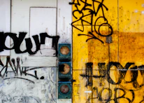 Close-up of a mixed-media installation combining photography and drawing on a weathered wall.