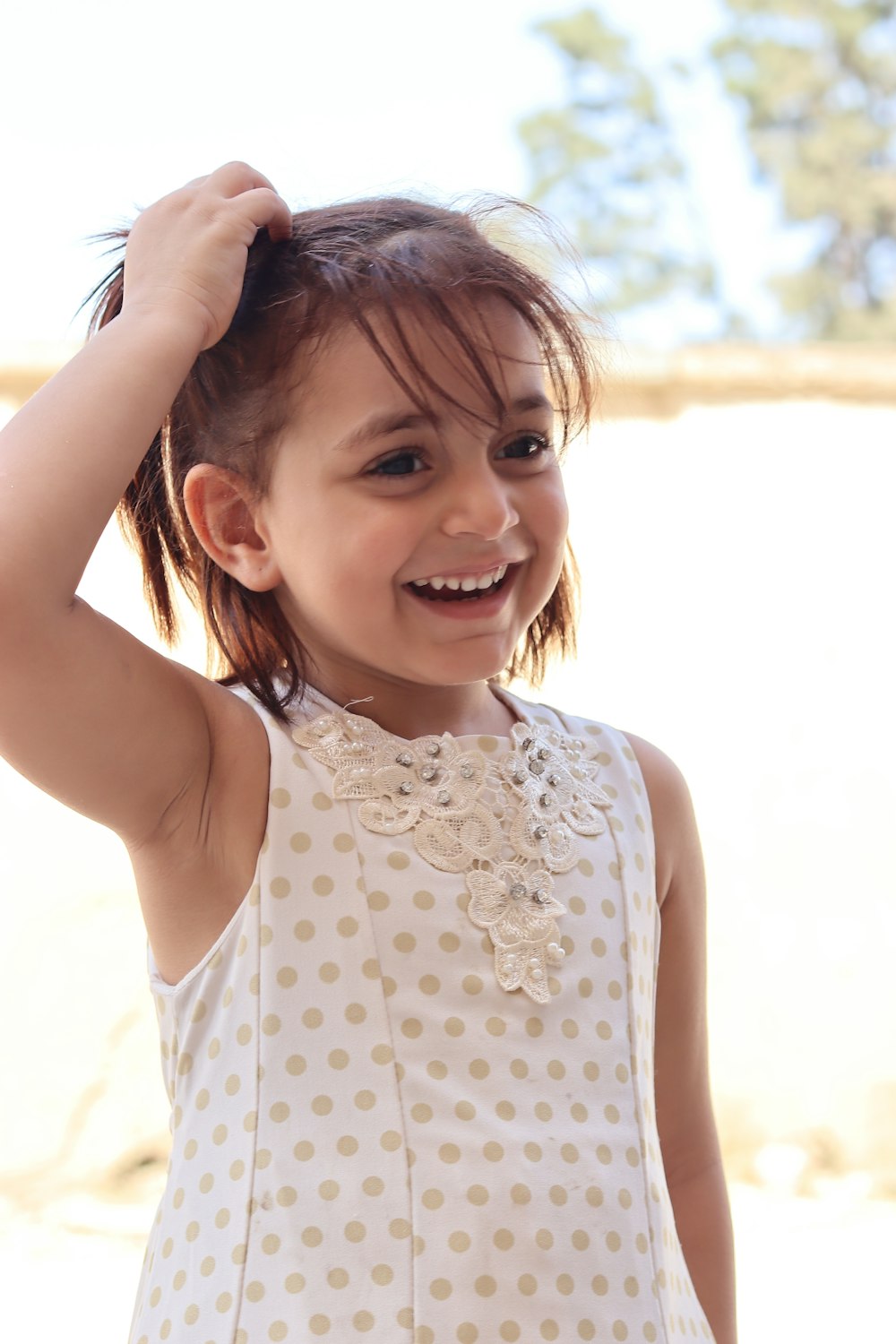 a girl smiling and holding her hair