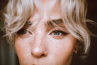 Close-up of a sun-kissed face with delicate, natural freckles tattooed on the cheeks and nose.
