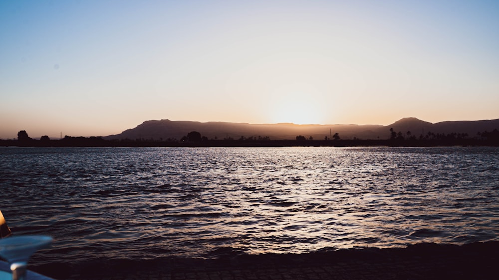 a body of water with hills in the background