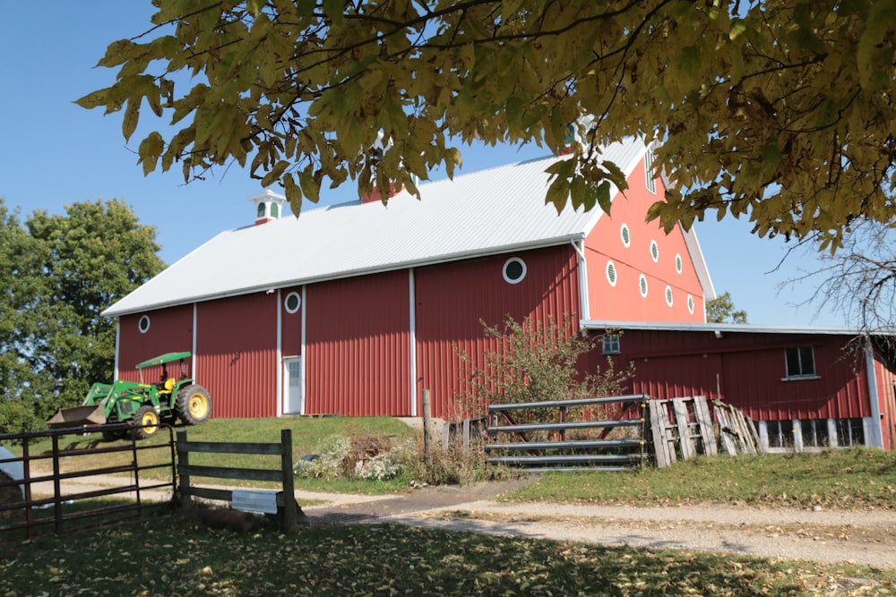 a red barn with a tractor in front of it