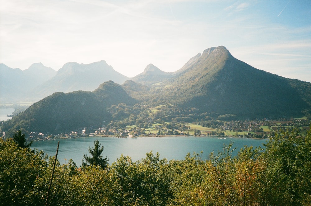 a body of water with trees and mountains in the background