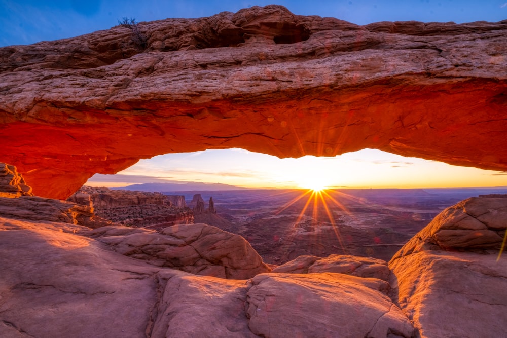 a large rock arch with a bright light shining through