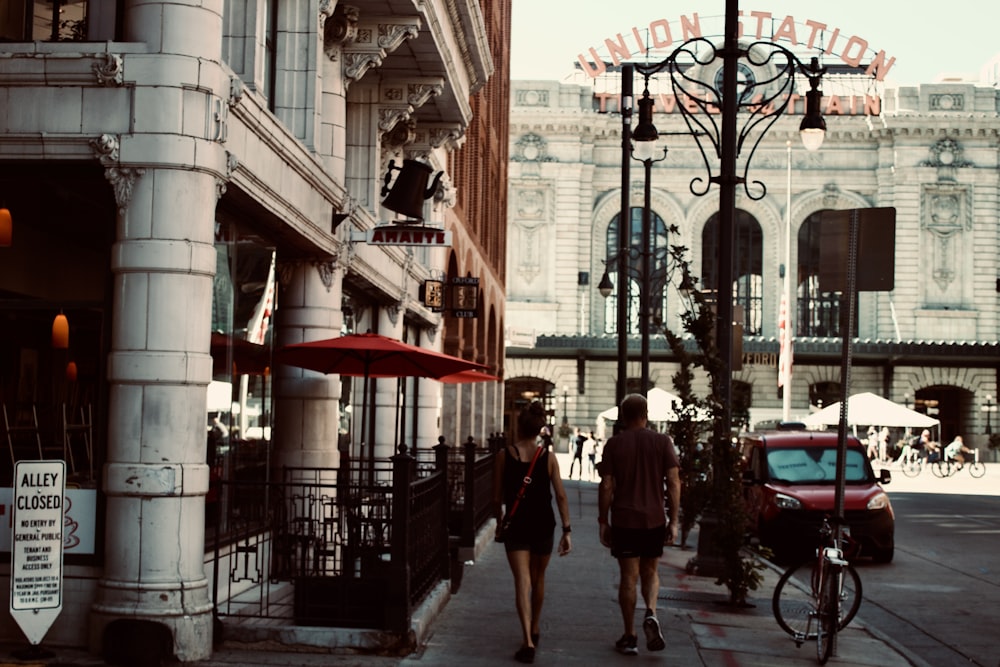 a couple walking down a sidewalk