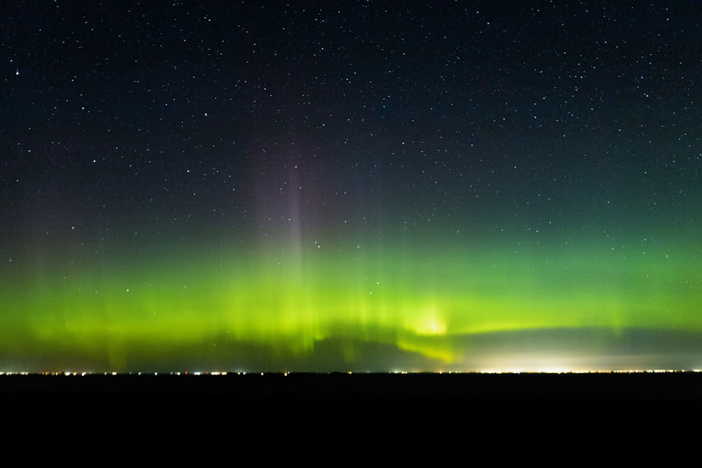 a green and purple aurora in the sky