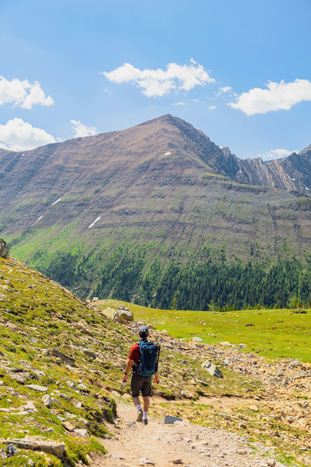 a man walking on a trail in a mountain