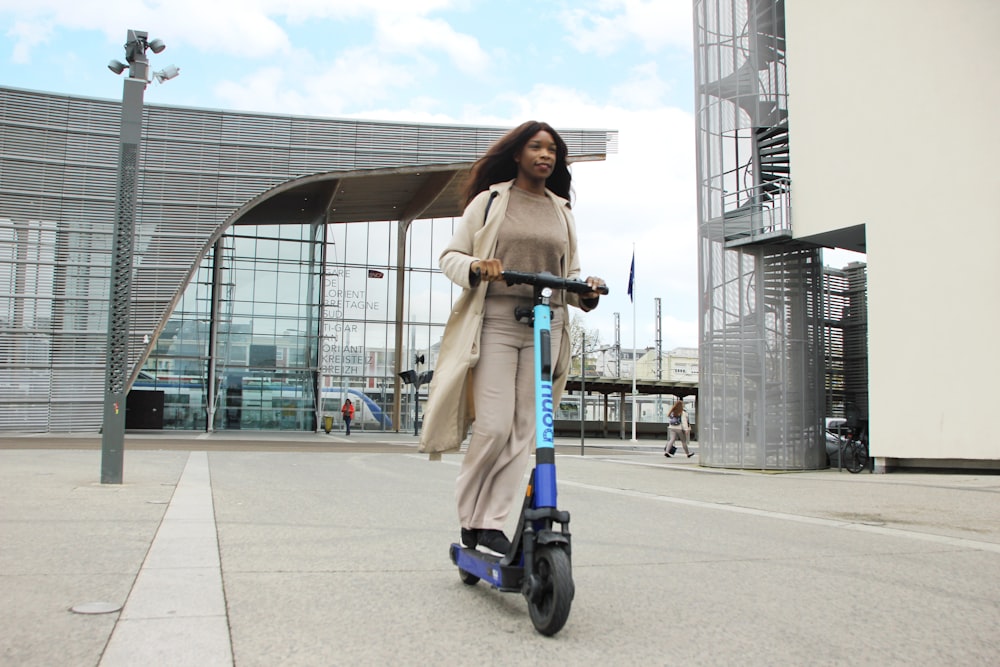 una persona in un cappotto lungo su uno scooter