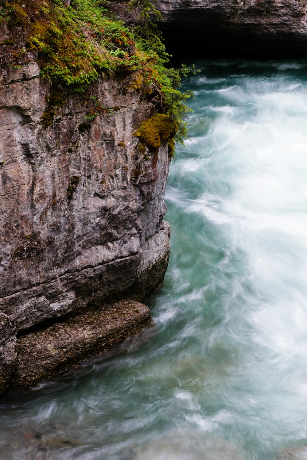 a rocky cliff with a waterfall