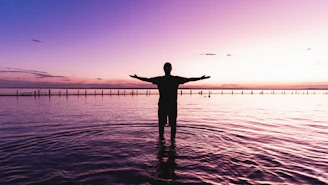 a person standing in water with arms outstretched