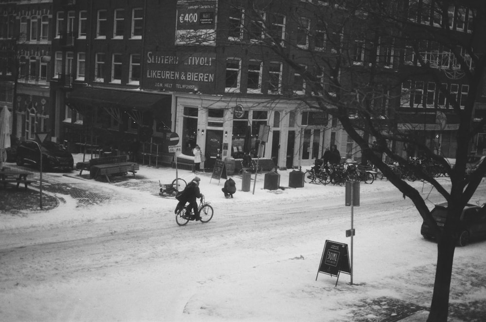 a person riding a bicycle down a snowy street