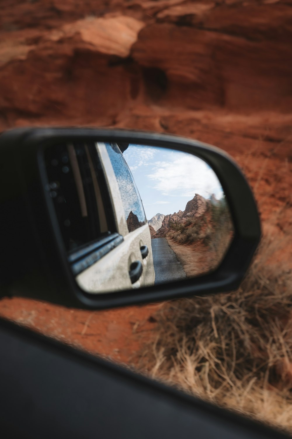 a car mirror showing a canyon