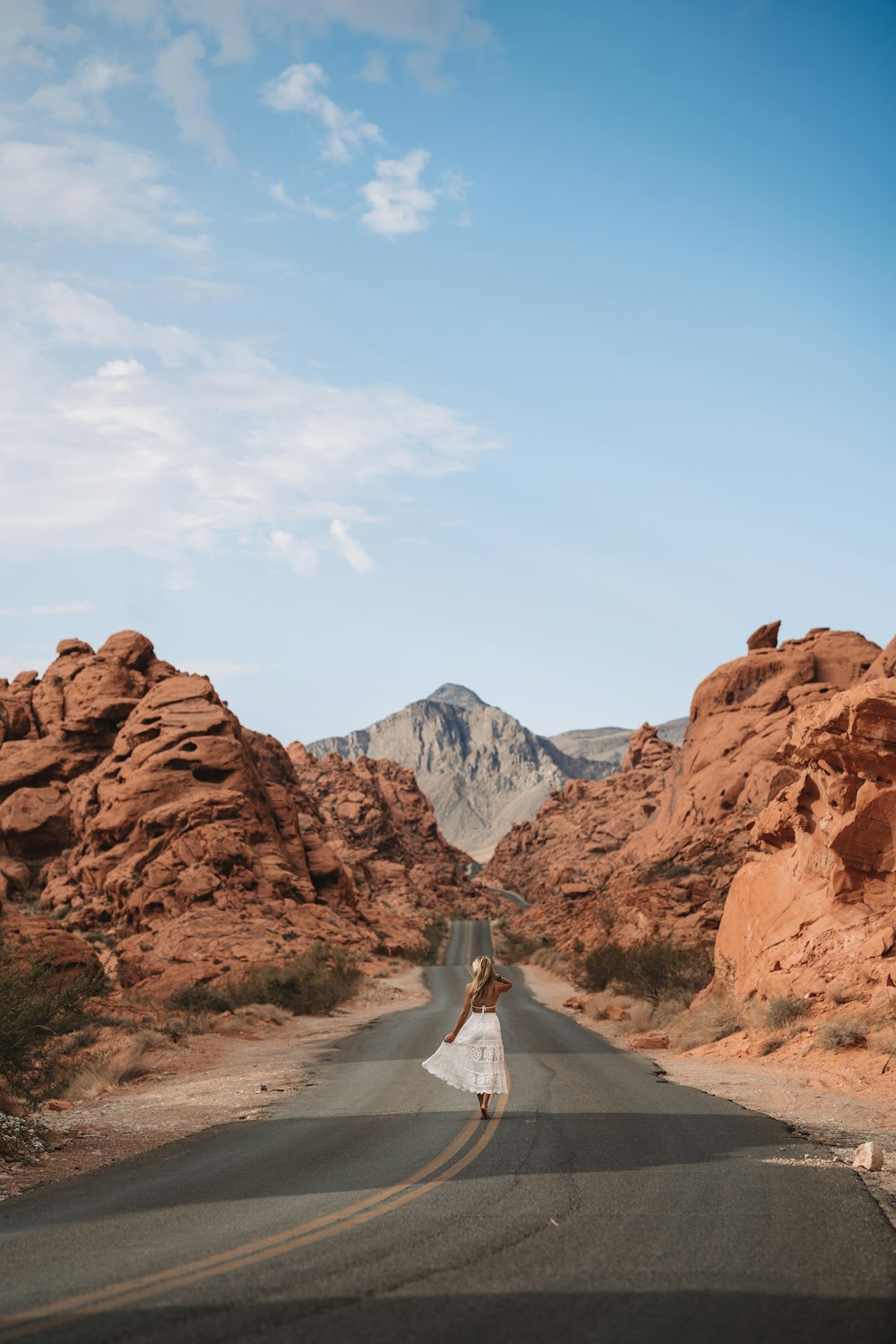 a man walking on a road in the desert