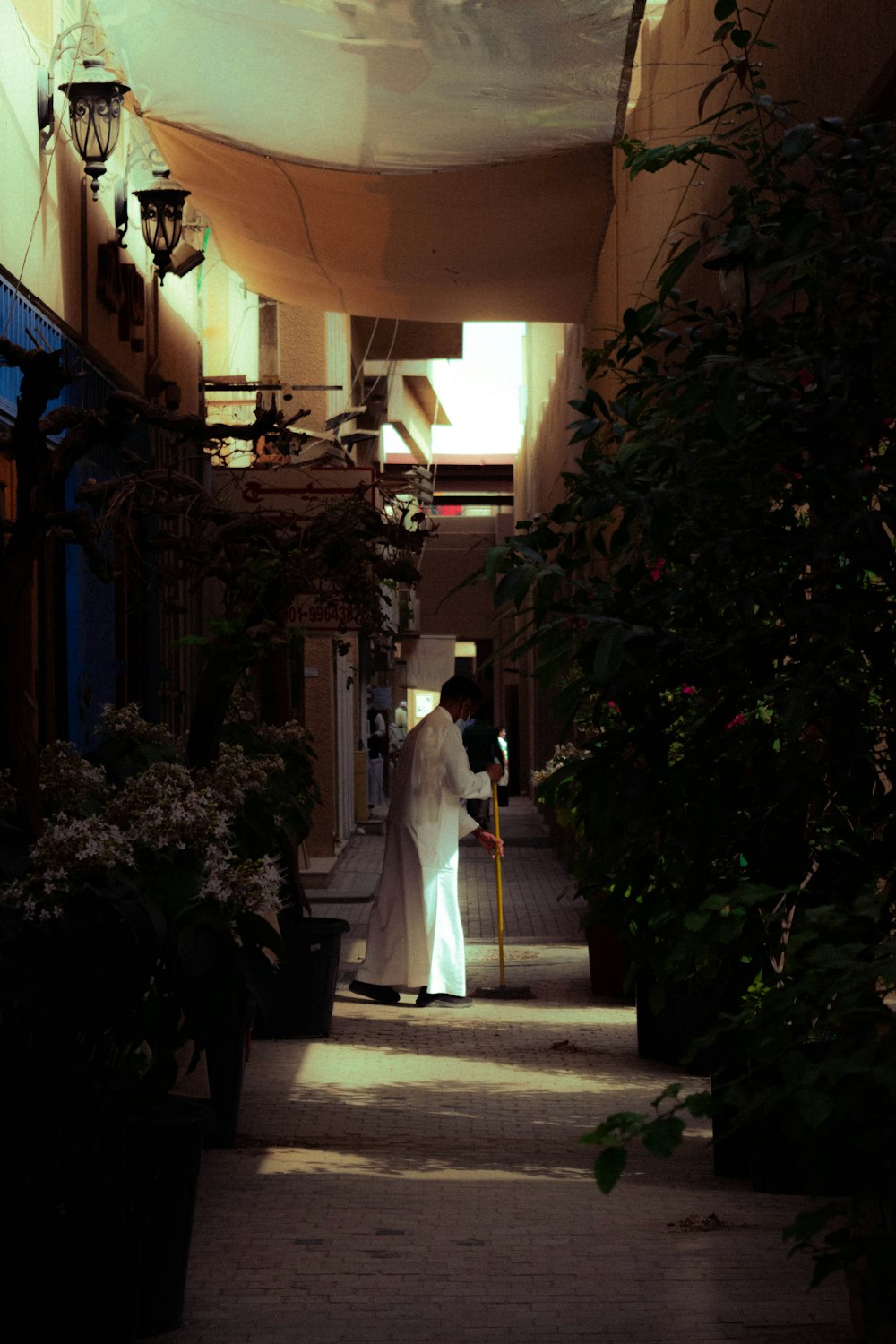 a person in a white robe walking down a sidewalk