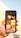 A hand holds a smartphone displaying a search result for animals. The screen shows a grid of nine images, featuring various animals including a parrot, cat, bird, and lion.