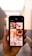 A hand is holding a smartphone displaying images related to newborns. The screen shows a grid of photos, including close-ups of baby feet, a baby wrapped in a blanket, and a baby being held by an adult. The background appears to be an alleyway with blurred walls and a light source visible.